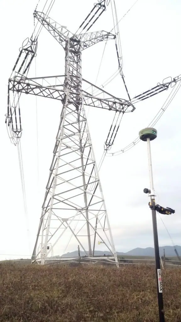 GNSS prijímač na výtyčke pod stožiarom vysokého napätia